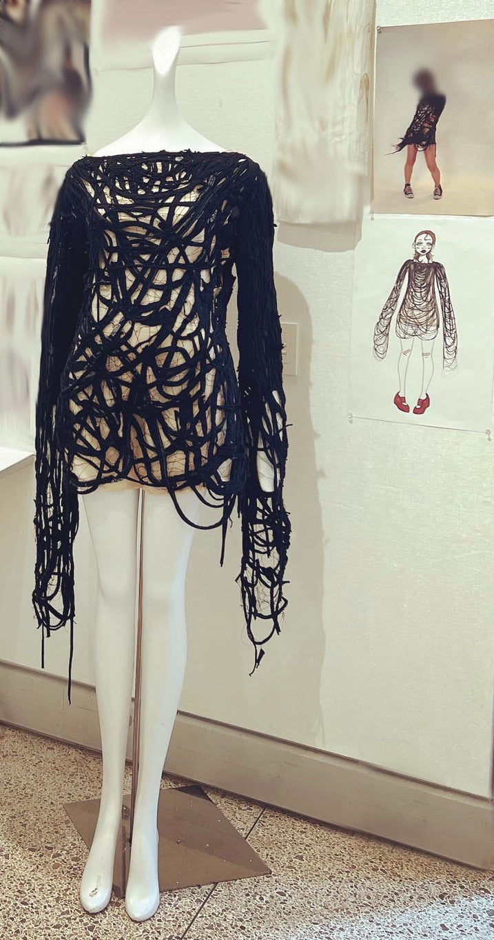 Long sleeve black top made of strings on mannequin