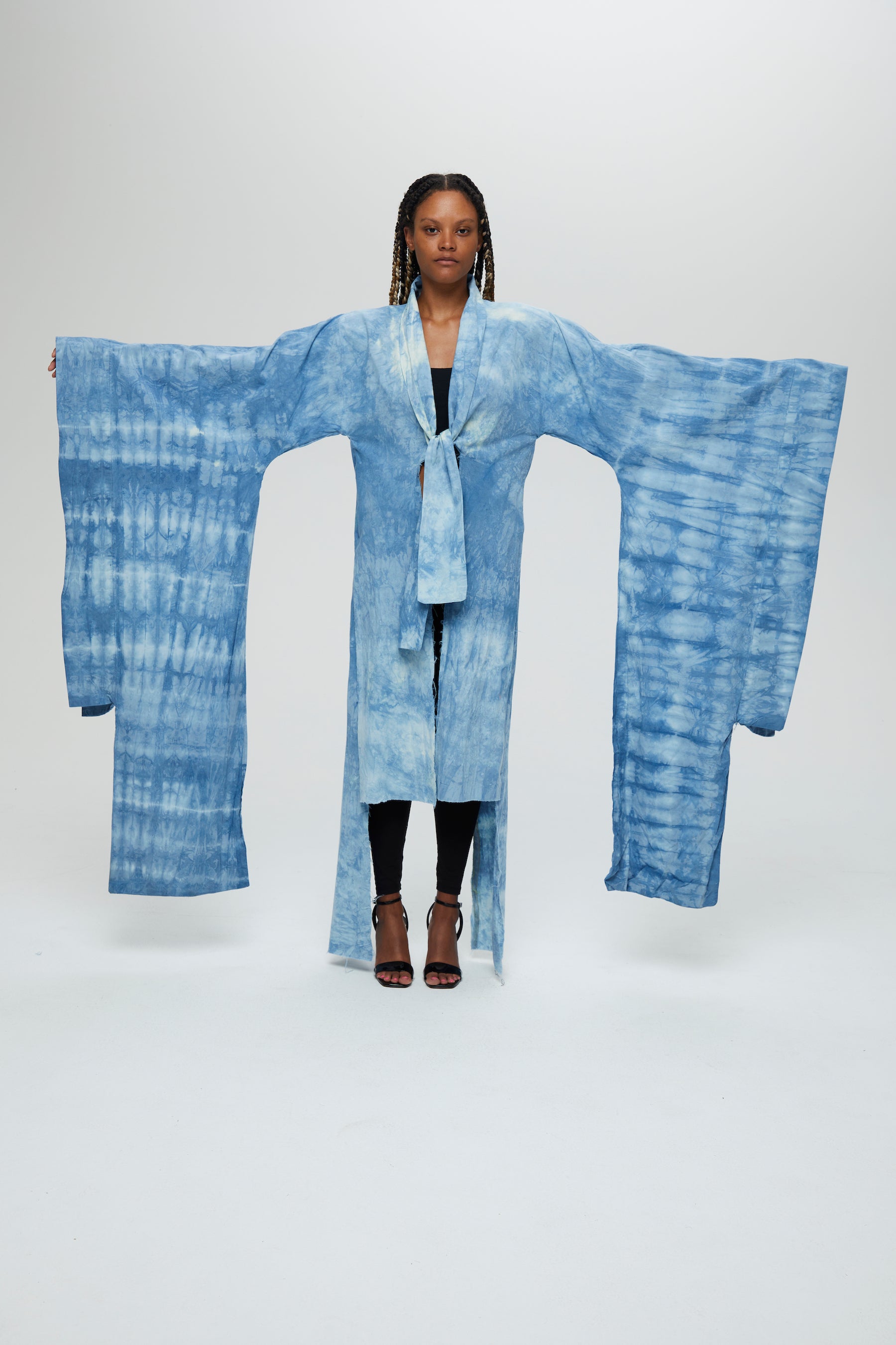 Akira Jacket Description - 100% cotton, knee length, flared sleeves front tie  Color - Indigo arashi shibori dyed  front view with arms art