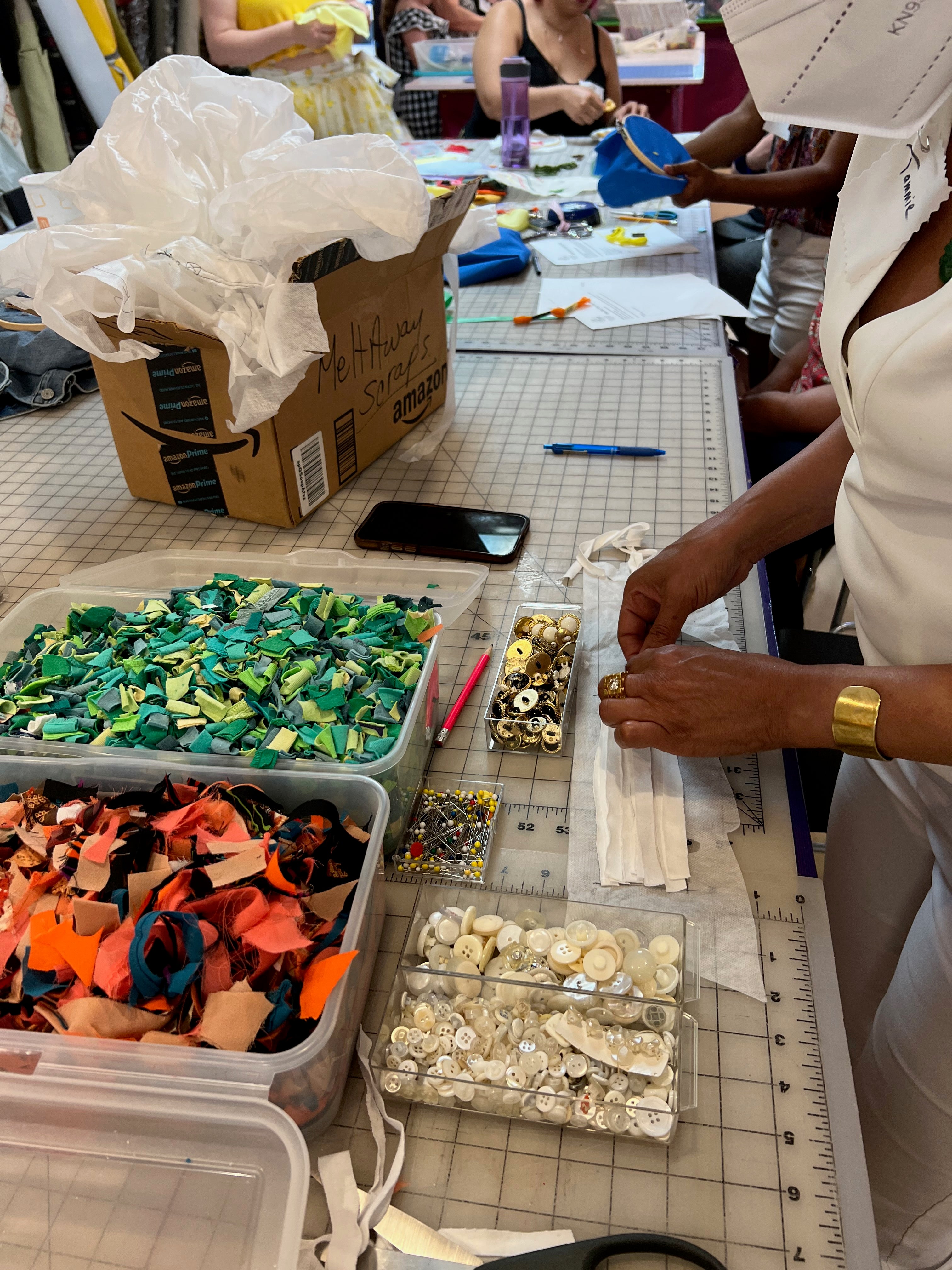 Reclem fabric strips and trims at work station in bins being used by person