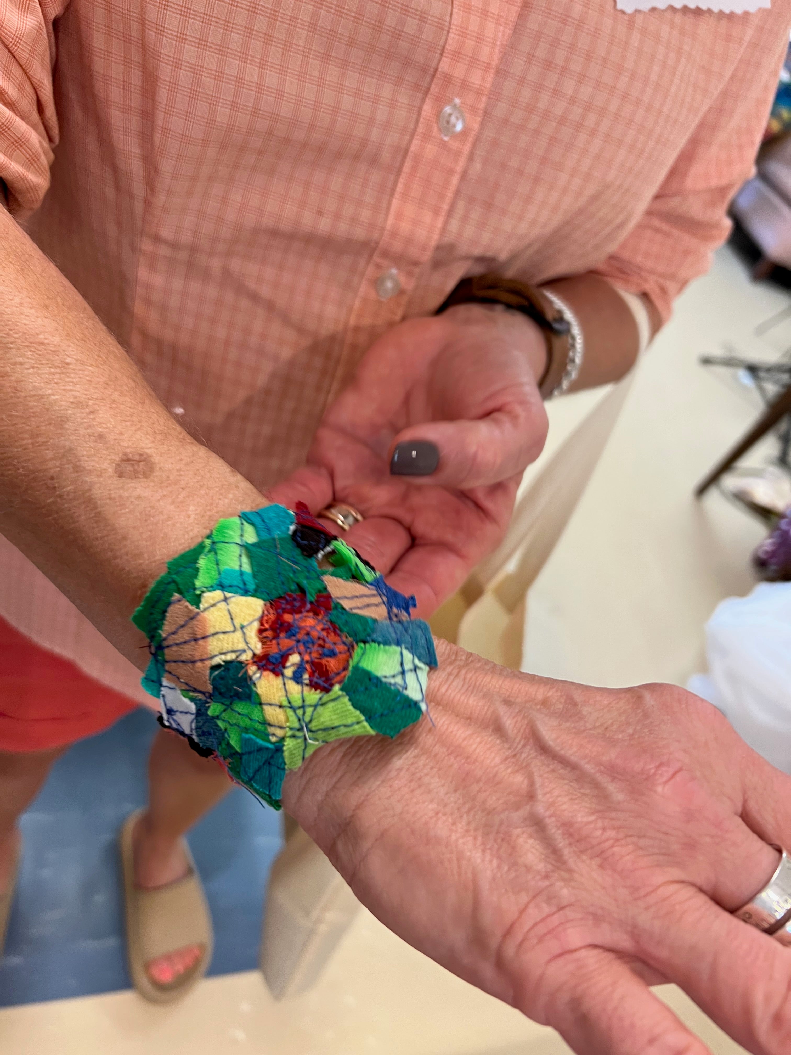 Person showing off bracelet made of fabric during reclem workshop