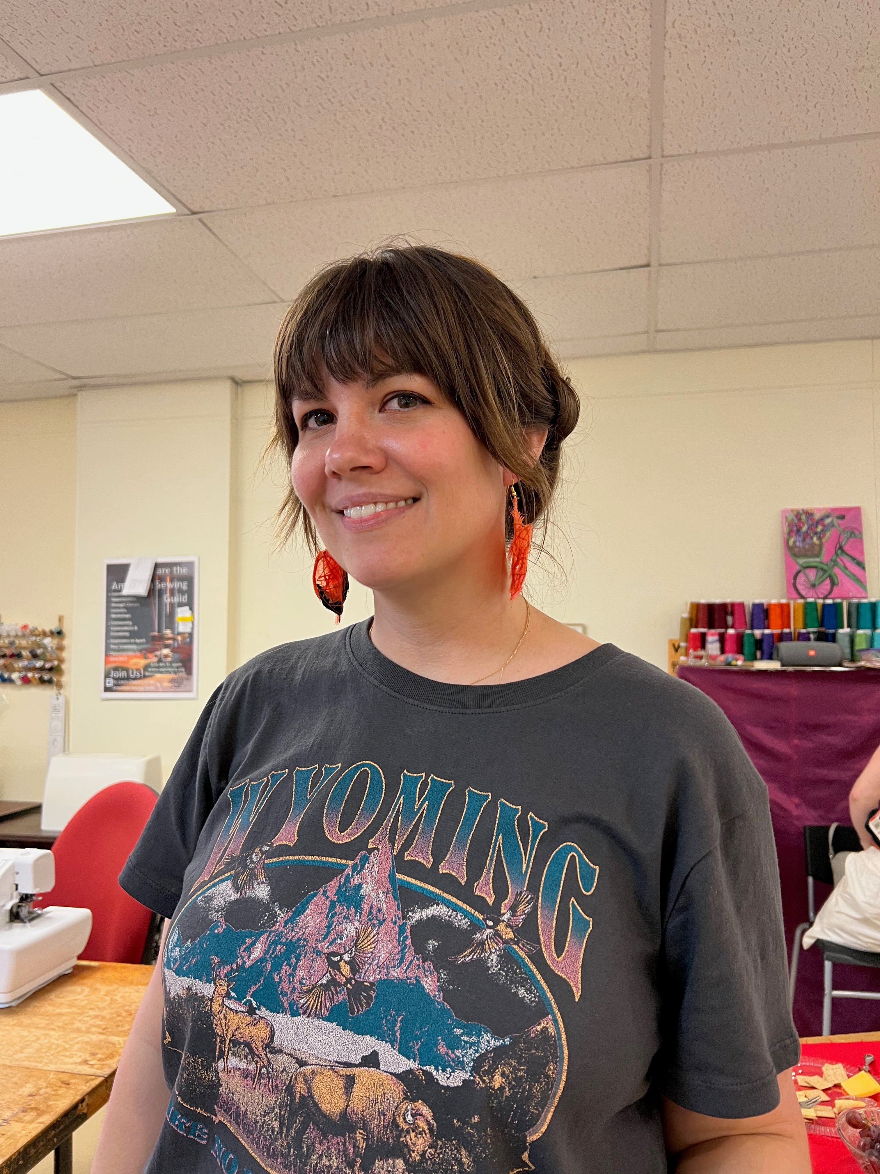 woman showing off earrings made during reclem workshop